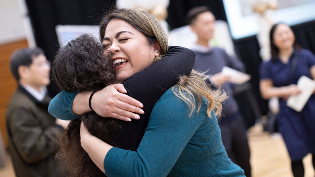 A medical student embraces her family member after learning about her residency match