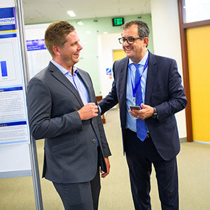 Dr. Aziz Benbrahim smiling and chatting with student Justin Cole at the School of Medicine